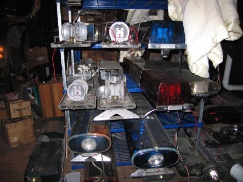 2001 Ford Crown Victoria - A collection of emergency vehicle light bars and components are organized on storage shelves.