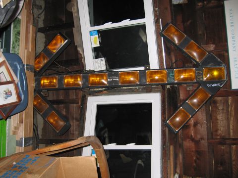 2001 Ford Crown Victoria - A directional light bar with multiple amber lights is mounted on a rustic wooden wall.