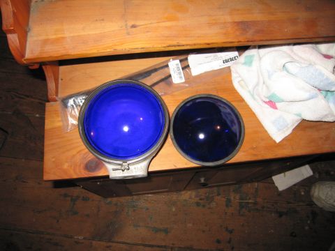 2001 Ford Crown Victoria - Two blue glass lenses are displayed on a wooden table, with a towel and packaging nearby.