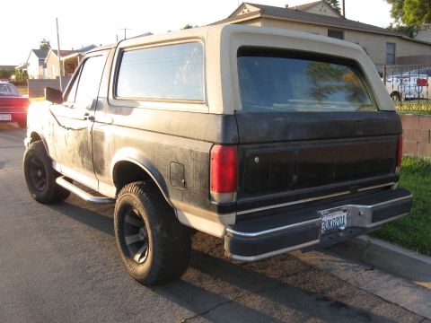 1990 Ford Bronco - Rear view of a 1990 Ford Bronco with a two-tone paint scheme and aftermarket wheels.