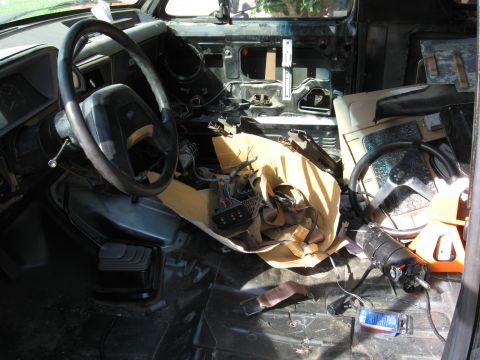 1990 Ford Bronco - The interior of a vehicle is shown in a state of disassembly, with the steering wheel and various components exposed.