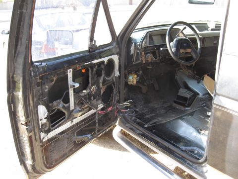 1990 Ford Bronco - Interior view of a 1990 Ford Bronco, with the driver's side door panel removed for access to components.