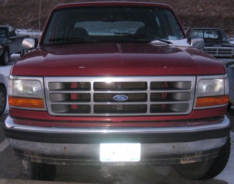 1994 Ford Bronco - This red Ford truck is parked outside in what appears to be a snowy environment.