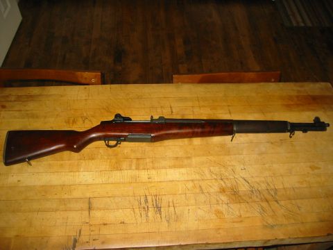 1996 Ford Bronco - A rifle with a wooden stock and metal components is displayed on a wooden table.
