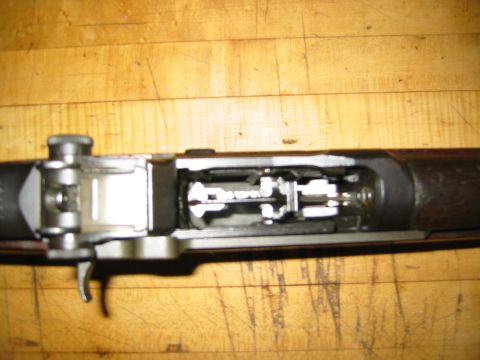1996 Ford Bronco - The internal mechanism of an M1 Garand rifle is visible, resting on a wooden surface.