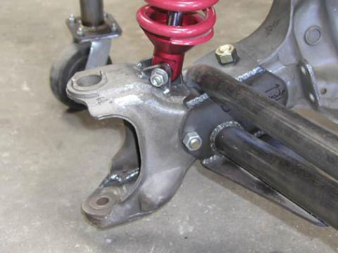 1984 Ford Bronco - A close-up view of a vehicle's suspension component, including a red coilover shock absorber.