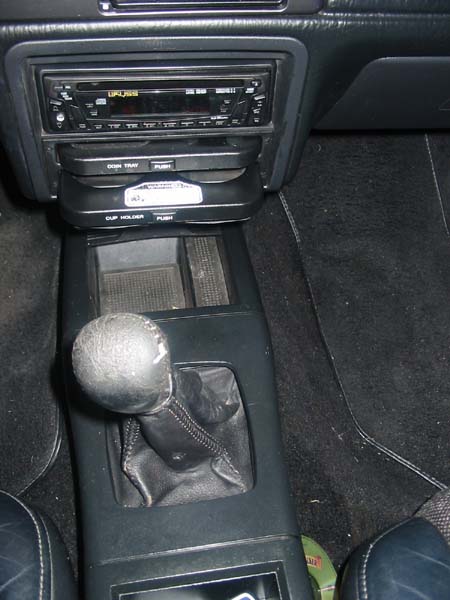 1990 Ford Taurus - Close-up of a car's interior, focusing on the gear shifter and dashboard electronics.