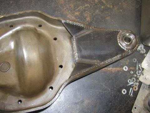 1984 Ford Bronco - A custom-welded differential cover sits on a workbench with hardware.