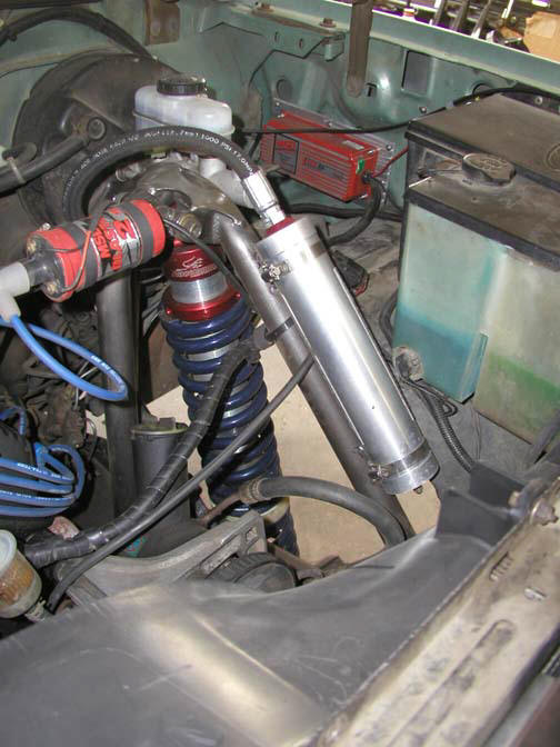 engine bay with aftermarket shocks, brake fluid reservoir, and ignition coil