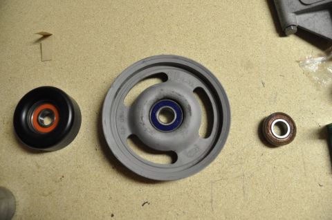 1996 Ford Bronco - A pulley with a Ford logo is shown alongside two bearings, likely for automotive repair.