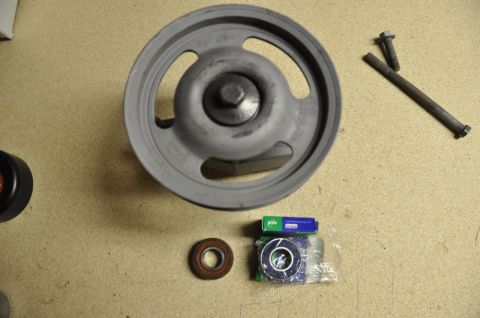 1996 Ford Bronco - Pulley, bearings, and bolts laid out on a surface.