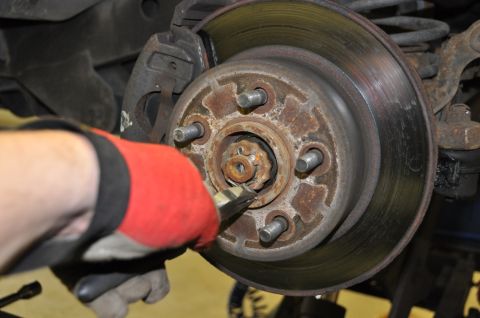 1996 Ford Bronco - Working on a vehicle's brake system, focusing on the rotor and hub.