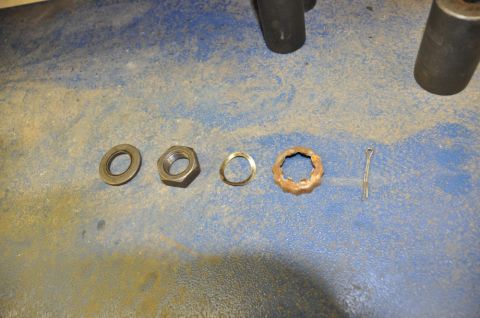 1996 Ford Bronco - Hub components including nuts, washer, toothed washer, and cotter pin are shown on a workbench.
