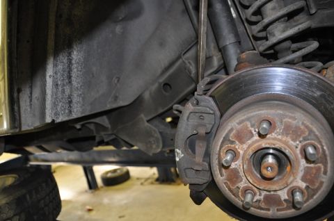 1996 Ford Bronco - Close-up view of a vehicle's brake system, showing the rotor, caliper, and suspension components.