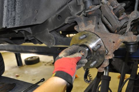 1996 Ford Bronco - Mechanic installing a new wheel hub bearing during a repair.