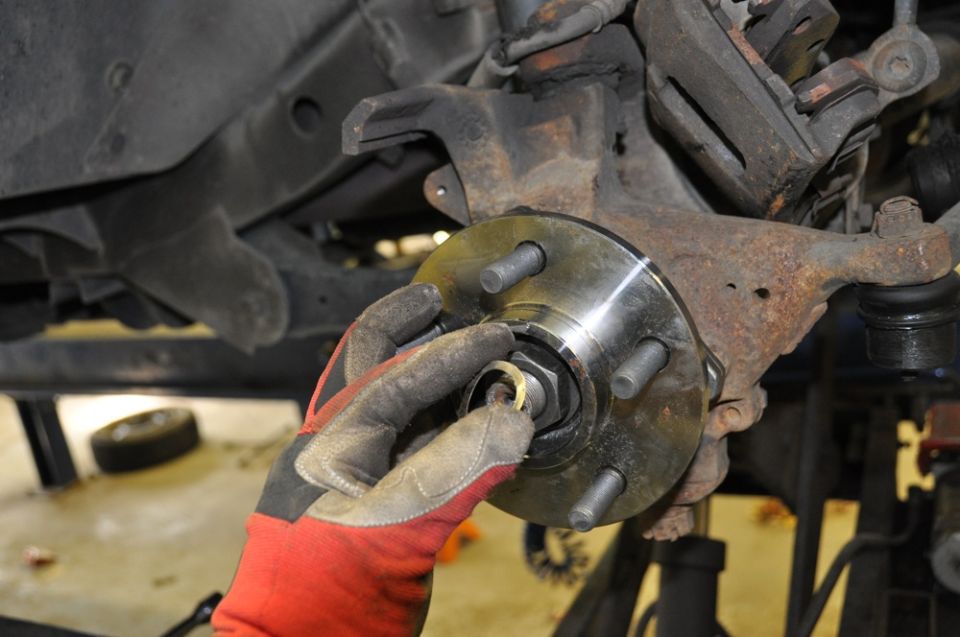 Gloved hands installing a new wheel hub assembly
