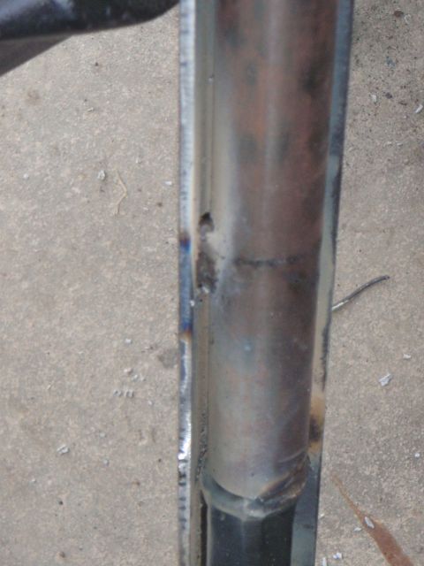 1996 Ford Bronco - A close-up view shows a welded metal component, possibly part of a vehicle's frame or suspension system, resting on a concrete surface.