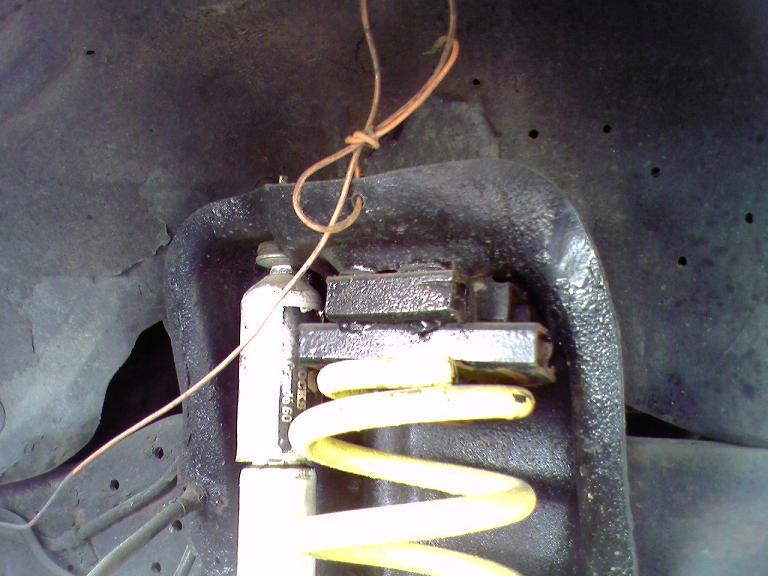 1996 Ford Bronco suspension with yellow coil spring and orange wire.