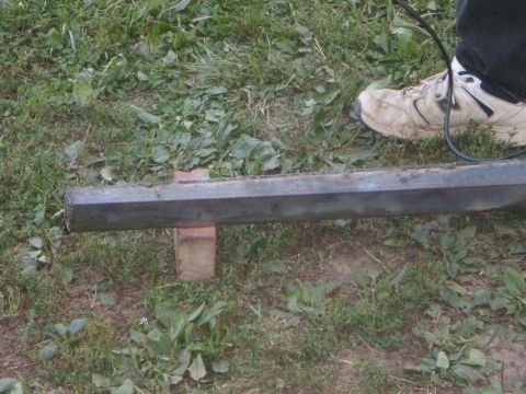 1996 Ford Bronco - A metal beam rests on a brick, with a worn white athletic shoe and a black cable visible in the background.