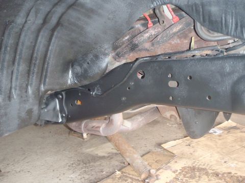 1996 Ford Bronco - A close-up view of the underside of a 1996 Ford Bronco, showing the frame and suspension components that have been recently painted black.