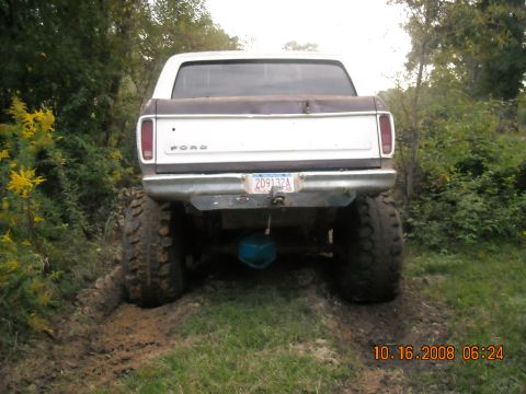 1979 Ford Bronco - This lifted Ford truck is stuck in the mud, with its rear end facing the camera.