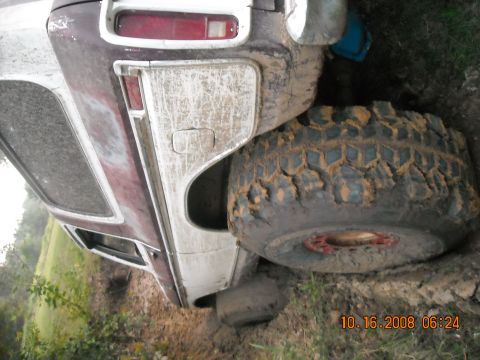 1979 Ford Bronco - A muddy 1978 Ford Bronco is stuck in the dirt, with its rear tire partially submerged.