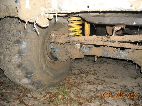1979 Ford Bronco - Close-up of a heavily soiled vehicle's wheel well and suspension system.