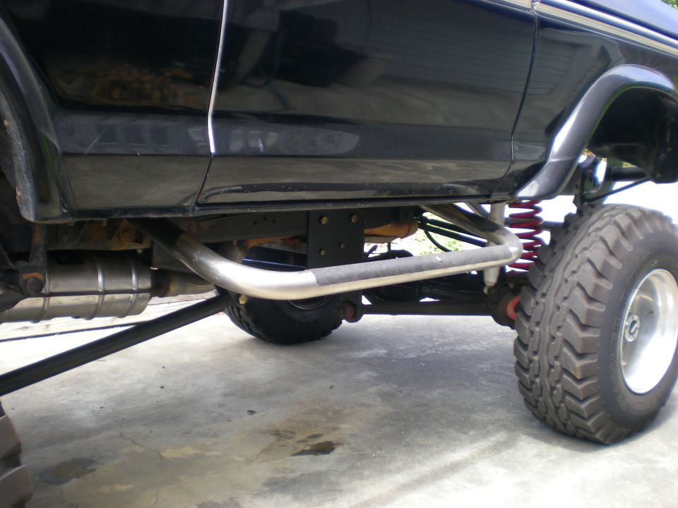 Side view of a lifted 4x4 truck's suspension and exhaust system