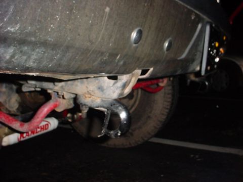 1989 Ford Bronco - Close-up of a vehicle's rear bumper and suspension, showing a tow hitch and a red Rancho component.