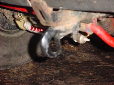 1989 Ford Bronco - Undercarriage view shows a red suspension part and a shock absorber with visible lettering.