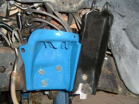 1984 Ford Bronco - A close-up view of a vehicle's suspension system, focusing on a newly painted blue bracket.