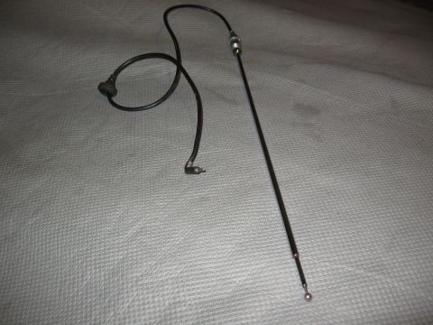 1968 Shelby GT500 - A black car antenna with its coiled wire and connector is shown against a textured gray background.
