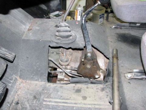 1978 Ford Bronco - Close-up of the floor console area of a vehicle, showing manual transmission shifters and pedals.