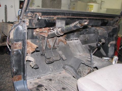1976 Ford Bronco - The interior of a vehicle is shown, with exposed metal and parts, suggesting it is in a state of repair or restoration.