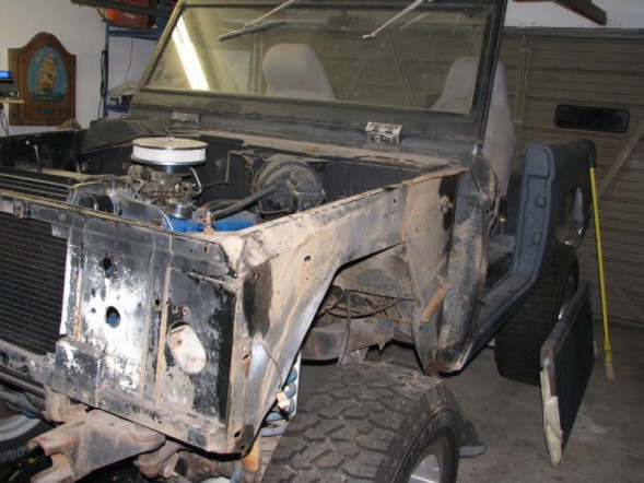 1976 Ford Bronco front end with engine exposed, undergoing restoration