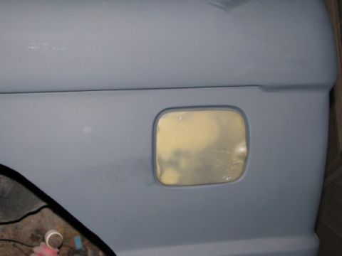 1976 Ford Bronco - This vehicle body panel is prepped for paint, with the fuel door area visible.