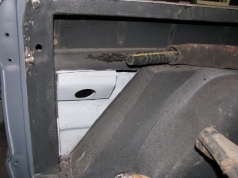 1976 Ford Bronco - Close-up view of the interior of a vehicle, focusing on structural components and a hose.