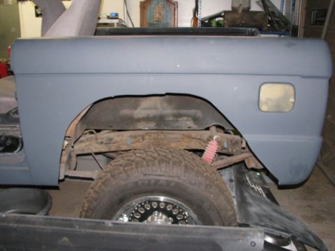 1976 Ford Bronco - The rear fender and wheel well of a 1976 Ford Bronco, shown in gray primer during a build.