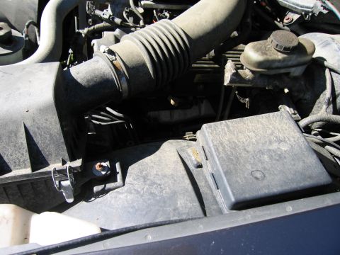 1991 Ford LTD Crown Victoria - Close-up view of a dusty engine bay, focusing on the air intake system and electrical components.