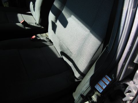 1991 Ford LTD Crown Victoria - Interior view of a car's front seats and door jamb, with sunlight casting shadows.