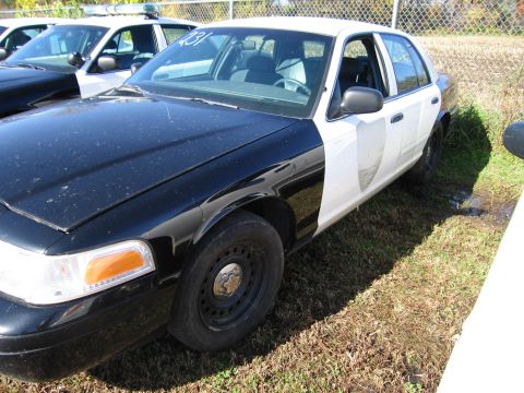 1991 Ford LTD Crown Victoria - A black and white police car is parked next to another police car.