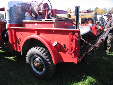 1991 Ford LTD Crown Victoria - Rear view of a red fire truck equipped with a hose reel and chains on its tailgate.