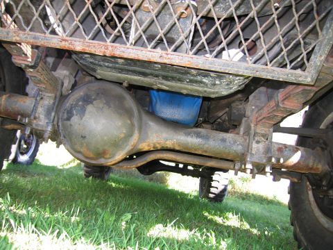 1991 Ford LTD Crown Victoria - Undercarriage view of a vehicle's rear axle and suspension system, showing leaf springs and differential housing.