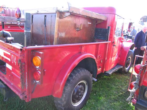 1991 Ford LTD Crown Victoria - Close-up view of the rear of a vintage red fire truck, with another vehicle visible to the right.