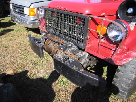 1991 Ford LTD Crown Victoria - Front view of a red truck equipped with a winch and a heavy-duty bumper, parked next to a silver truck.