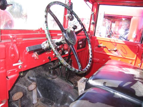 1991 Ford LTD Crown Victoria - Interior view of a vintage red truck, focusing on the steering wheel and dashboard details.