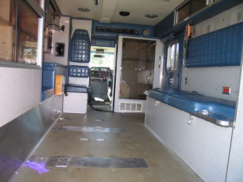 1991 Ford LTD Crown Victoria - The interior of an ambulance shows empty seating and floor space, ready for equipment.