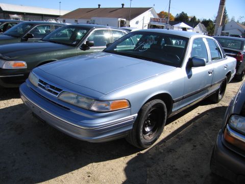 1991 Ford LTD Crown Victoria - A light blue 1991 Ford Crown Victoria LTD sedan is parked in a lot with other vehicles.