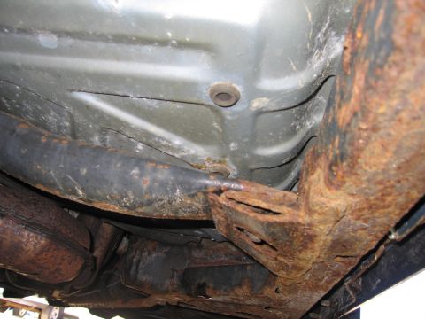 1991 Ford LTD Crown Victoria - The undercarriage of the vehicle displays extensive rust damage, particularly on the frame and exhaust components.