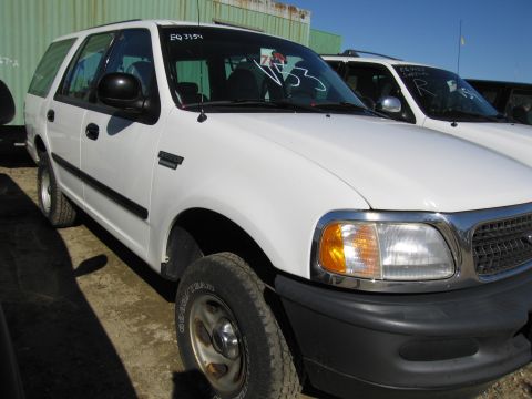 1991 Ford LTD Crown Victoria - Two white SUVs are parked side-by-side in an outdoor lot.